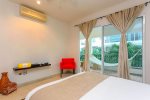 The master suite with double bed, en suite bathroom, pool view and private balcony access